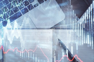 Borsa grafiği ve masa arkasındaki en üst görünüm bilgisayarı. Çoklu maruz kalma. Finansal eğitim kavramı.