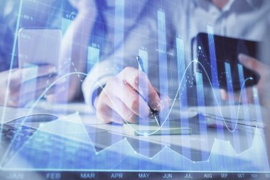 Kadın ve erkeğin birlikte çalışması ve finansal grafik hologramı. İş konsepti. Bilgisayar arkaplanı.