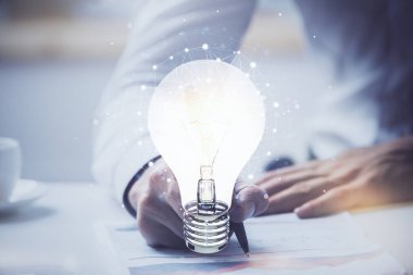 Fütüristik arayüzde insanoğlunun el fonu ile Ampul lambası fikir simgesi görünümü. Çift pozlama.