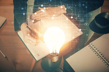 Arka planda not alan bir kadının eline ampul çizmek. Fikir kavramı. Çift pozlama