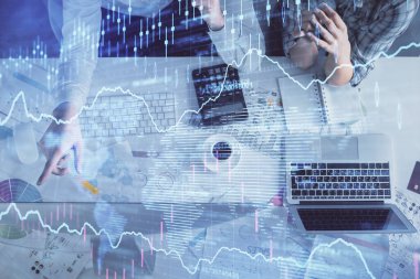 Kadın ve erkeğin birlikte çalışması ve finansal grafik hologramı çizimi. Pazar analizi konsepti. Bilgisayar arkaplanı. Üst Görünüm.