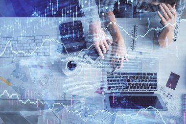 Kadın ve erkeğin birlikte çalışması ve finansal grafik hologramı çizimi. Pazar analizi konsepti. Bilgisayar arkaplanı. Üst Görünüm.