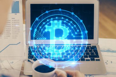 Blockchain temalı holograma ve bilgisayar arkaplanlı masaya çift pozlama. Bitcoin şifreleme para birimi kavramı.