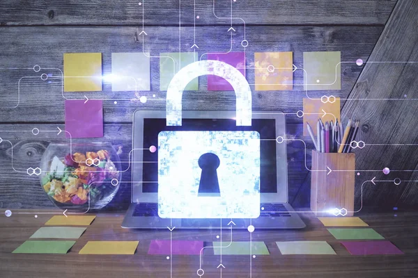 Double exposure of desktop with computer and lock icon hologram. Concept of data safety.