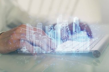 Arka planda bilgisayar üzerinde çalışan bir iş adamı ile yüksek teknoloji şehir çizimi. Akıllılık konsepti. Çift pozlama.