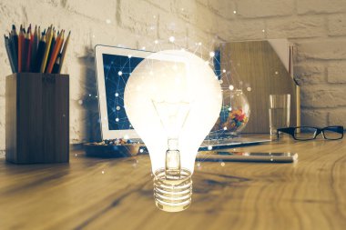 Bilgisayar ofisinde ampul simgesi hologramıyla birlikte. Çifte maruziyet. Fikir kavramı.