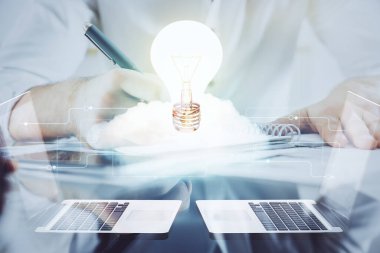 Ampul lambası fikir simgesinin gelecek arayüzü ve yazma adamı el altyapısı üzerindeki görüntüsü. Çift pozlama.