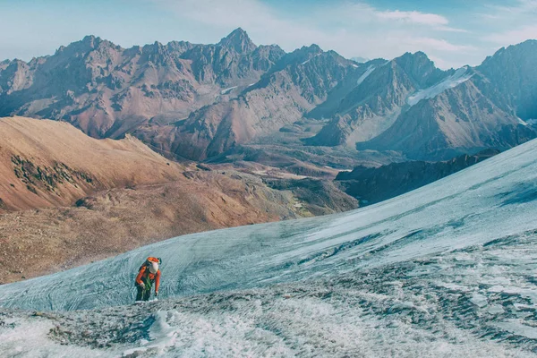 Maceracı adam dağın tepesinde duran ve canlı bir gün batımı sırasında güzel manzarayı