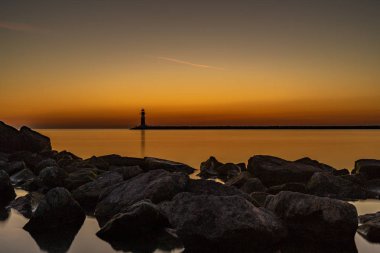 Güzel gün batımı deniz feneri ile bir liman girişinde