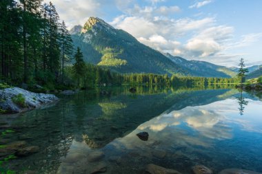 Açık bir dağ gölü. Arkasında kara bulutlar ve yüksek dağlar var.