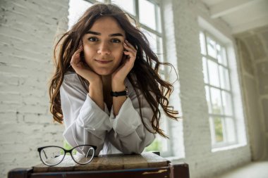 Genç Seksi güzel kız beyaz erkek gömlek çorap ve parlak oda penceresinde yakın bir sandalyede oturan gözlük gebe