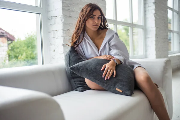 Burada gözlük yalan çevresinde yalan bir uzun saçlı Genç çok seksi çekici kız beyaz adamın gömlek parlak bir oda penceresinde yakınındaki beyaz kanepe oturur 