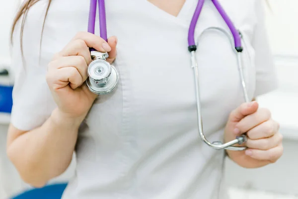 kadın doktor stetoskop ve boynunda asılı ve onu elleriyle desteklenen