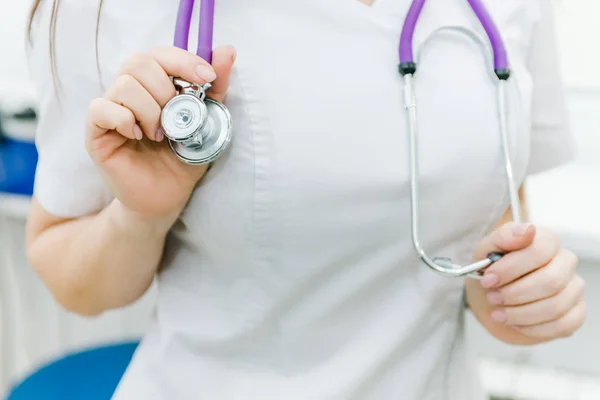 the female doctor hung a stethoscope on his neck and supported him with his hands