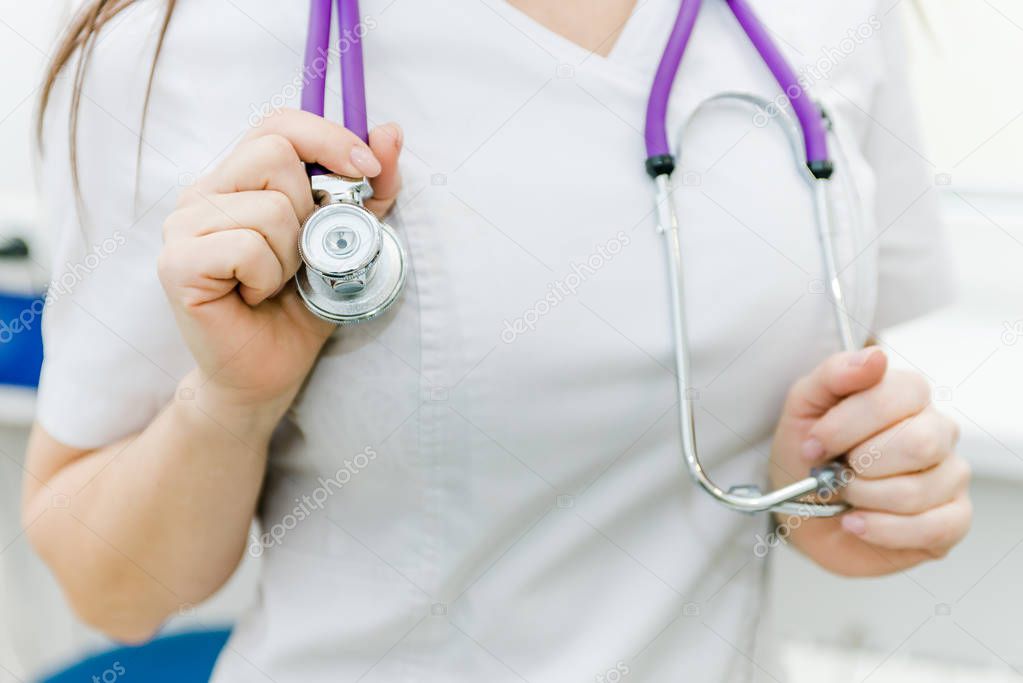 the female doctor hung a stethoscope on his neck and supported him with his hands