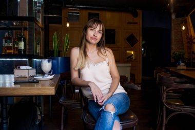 bir iskemle kot duygusal hoş ve seksi bir kafede oturan genç oldukça sevimli kız