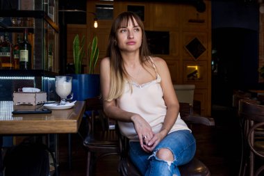 bir iskemle kot duygusal hoş ve seksi bir kafede oturan genç oldukça sevimli kız