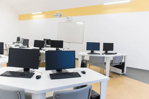 office room with computer tables with keyboard and mouse with a board and a projector