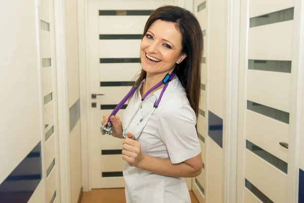 Young attractive attractive female doctor has hung a stethoscope on his neck and supports his hands