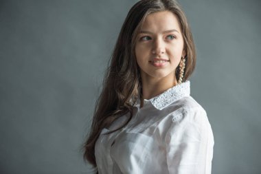 ahlaksız sarı saçlı beyaz bir gömlek giymiş güzel bir gülümseme ile güzel bir genç kızla portresi
