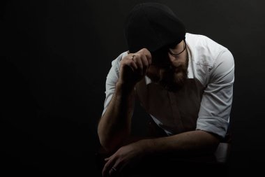 oldukça genç adam kavga bardaklarda ve bıyıklı bir siyah şapka ve beyaz gömlek şapkamı bir karanlık studio arka plan düzeltmek