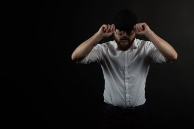 oldukça genç adam kavga bardaklarda ve bıyıklı bir siyah şapka ve beyaz gömlek şapkamı bir karanlık studio arka plan düzeltmek