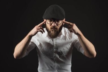 bir sakal ve bir siyah kap ve beyaz bir gömlek bir bıyık ile Gözlük Genç yakışıklı bir adam baş ağrısı gibi kafasına ellerini tutan, karanlık bir stüdyoda