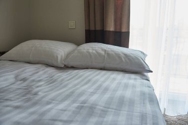 açık beyaz yastıklar hafif bir yatakta yatıyor