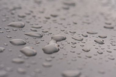 gri bir metal yüzeye yağmur damlaları