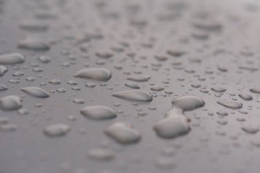 gri bir metal yüzeye yağmur damlaları