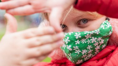 Sokakta yürürken maske takan 9 yaşındaki bir kızın portresi. Salgın, virüs, tecrit 