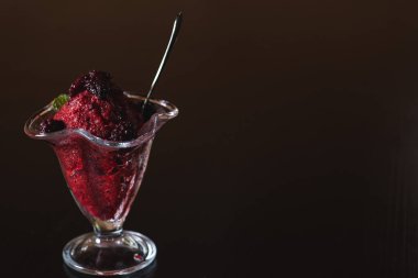 Tatlı, donmuş yoğurt ya da koyu gri arka planda şeffaf bir kabın içinde dondurma. Taze nane ile süslenmiş. Yaz tatlıları konsepti. Boşluğu kopyala.