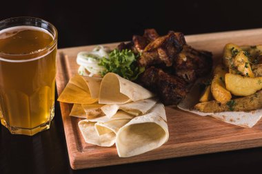 Izgara et, fırında patatesli kebap, ahşap tepside patates kızartması. 