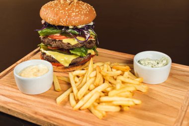Fast food hamburgerini yalıtılmış, ahşap zeminde Amerikan sağlıksız kalori yemeğini metin tasarımı için fotokopi alanı ile maketi, ızgara hamburger, biftek, peynir, domates öngörüsünü kapat.