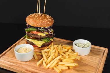 Fast food hamburgerini yalıtılmış, ahşap zeminde Amerikan sağlıksız kalori yemeğini metin tasarımı için fotokopi alanı ile maketi, ızgara hamburger, biftek, peynir, domates öngörüsünü kapat.