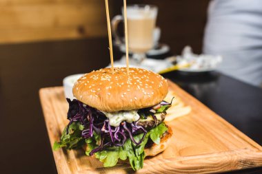 Fast food hamburgerini yalıtılmış, ahşap zeminde Amerikan sağlıksız kalori yemeğini metin tasarımı için fotokopi alanı ile maketi, ızgara hamburger, biftek, peynir, domates öngörüsünü kapat.