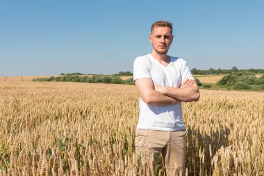 Altın buğday tarlasında geleneksel Ukrayna halk kostümlü genç ve yakışıklı bir adamın portresi..