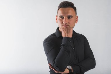 Beyaz arka planda izole edilmiş siyah gömlekli, yakışıklı, yuvarlak yüzlü bir adamın portresi.