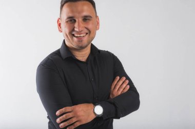 Beyaz arka planda izole edilmiş siyah gömlekli, yakışıklı, yuvarlak yüzlü bir adamın portresi.