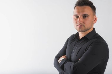 Beyaz arka planda izole edilmiş siyah gömlekli, yakışıklı, yuvarlak yüzlü bir adamın portresi.