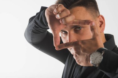 Adam ellerini yüzünün önünde tutuyor, onlara bakıyor. 