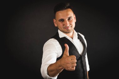 Genç ve çekici iş adamı, müşteri için metin ya da öğe eklemek için avuç üzerinde boş fotokopi alanı gösteriyor, mutlu ve heyecanlı görünüyor, beyaz gömlekle koyu arka planda izole edilmiş. 