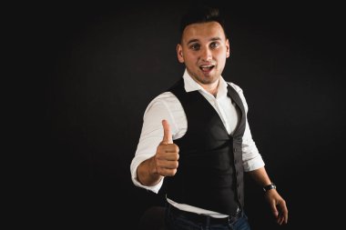 Genç ve çekici iş adamı, müşteri için metin ya da öğe eklemek için avuç üzerinde boş fotokopi alanı gösteriyor, mutlu ve heyecanlı görünüyor, beyaz gömlekle koyu arka planda izole edilmiş. 