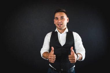 Genç ve çekici iş adamı, müşteri için metin ya da öğe eklemek için avuç üzerinde boş fotokopi alanı gösteriyor, mutlu ve heyecanlı görünüyor, beyaz gömlekle koyu arka planda izole edilmiş. 