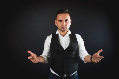 Genç ve çekici iş adamı, müşteri için metin ya da öğe eklemek için avuç üzerinde boş fotokopi alanı gösteriyor, mutlu ve heyecanlı görünüyor, beyaz gömlekle koyu arka planda izole edilmiş. 