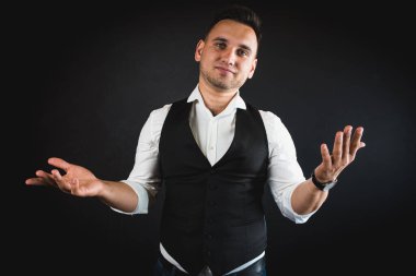 Genç ve çekici iş adamı, müşteri için metin ya da öğe eklemek için avuç üzerinde boş fotokopi alanı gösteriyor, mutlu ve heyecanlı görünüyor, beyaz gömlekle koyu arka planda izole edilmiş. 