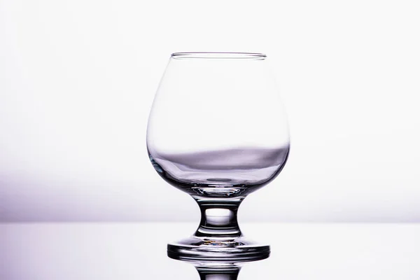 one transparent glass cognac glass isolated on a white background