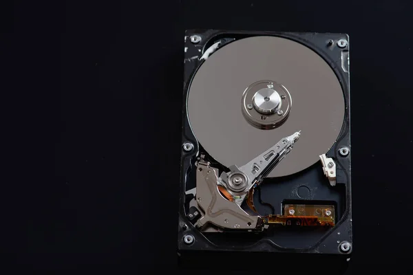 Low key, disassembled hard drive, on a black reflective background, information protection, restrained key, there is a place for an inscription
