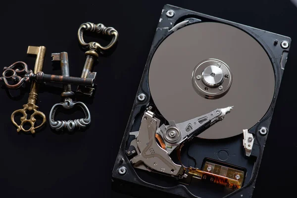 low key, hard drive on a dark background, next to the information protection lie antique metal keys there is a place for an inscription and a piece of paper for writing, the concept of information security