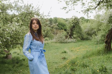 Bahar elma bahçesindeki güzel, genç bir kızın portresi.